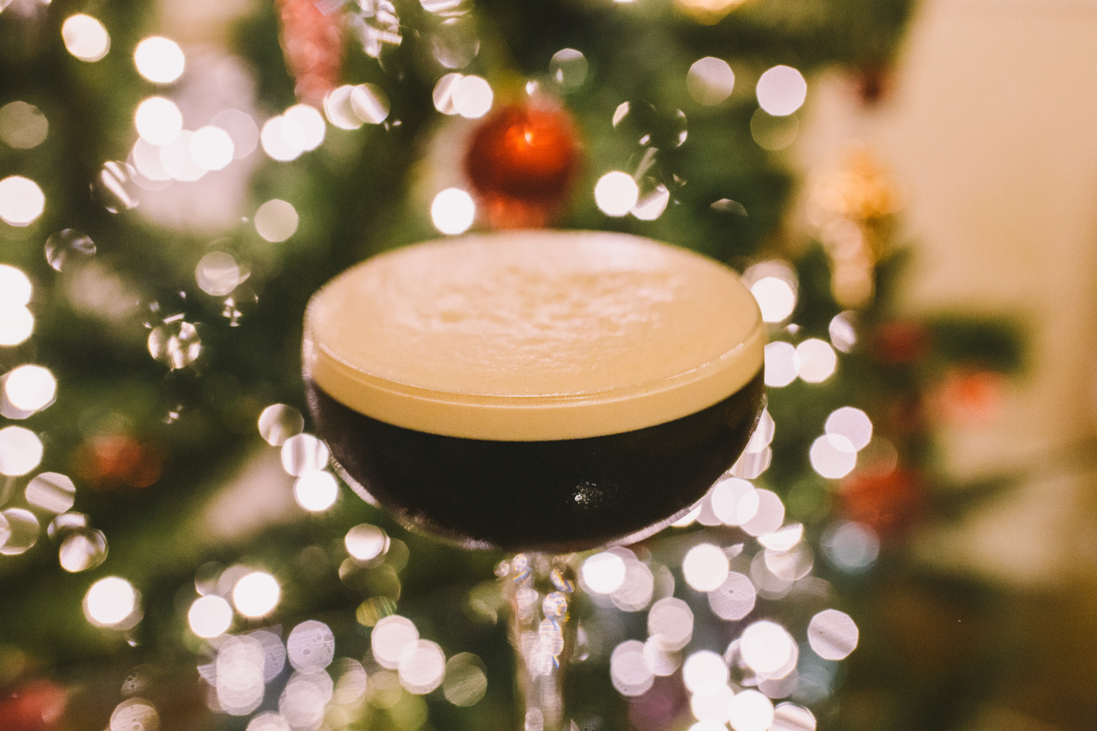 espresso martini in a cocktail glass by a Christmas tree shot by Lex Fleming Photo