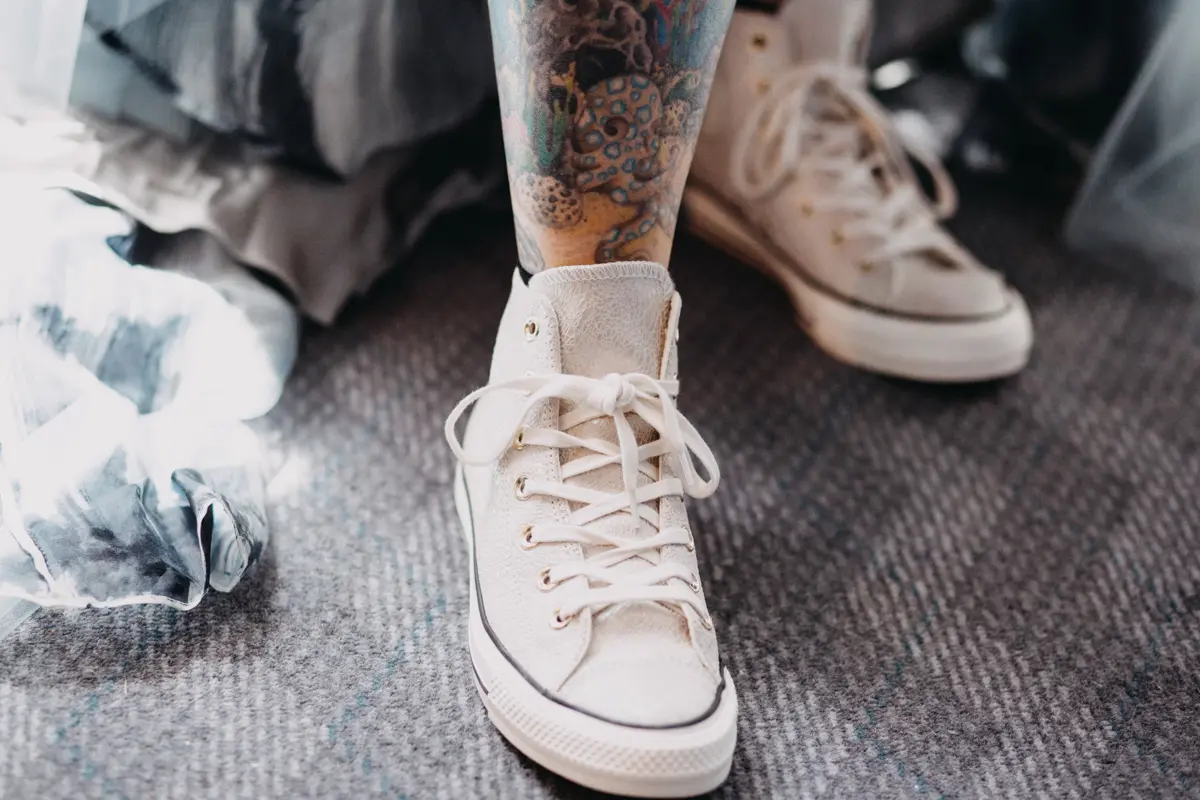 white leather wedding converse on tattooed bride